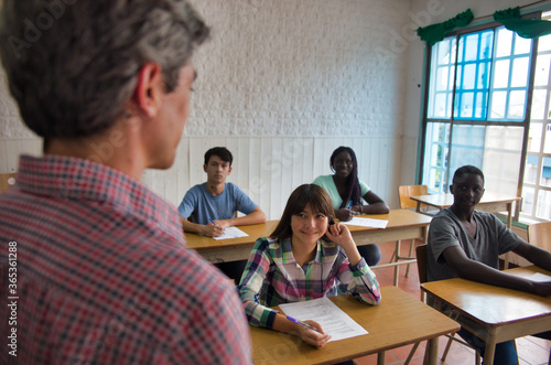 Teenagers at school. Multi ethnic classroom making test