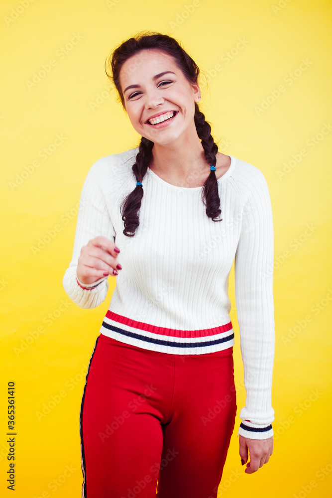 lifestyle people concept: pretty young school teenage girl having fun happy smiling on yellow background lifestyle people concept: pretty young school teenage girl having fun happy smiling on yellow background