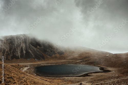 A view inside an active volcano in Toluca, Mexico. A lake inside with intense fog