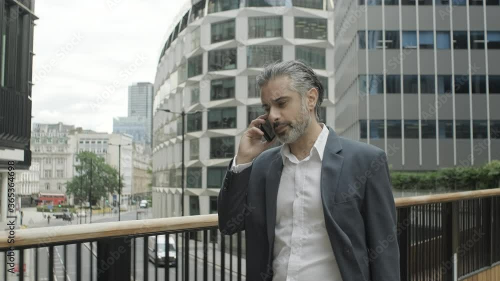Corporate business man on the move talking on mobile phone in the city of London Corporate business man on the move talking on mobile phone in the city of London