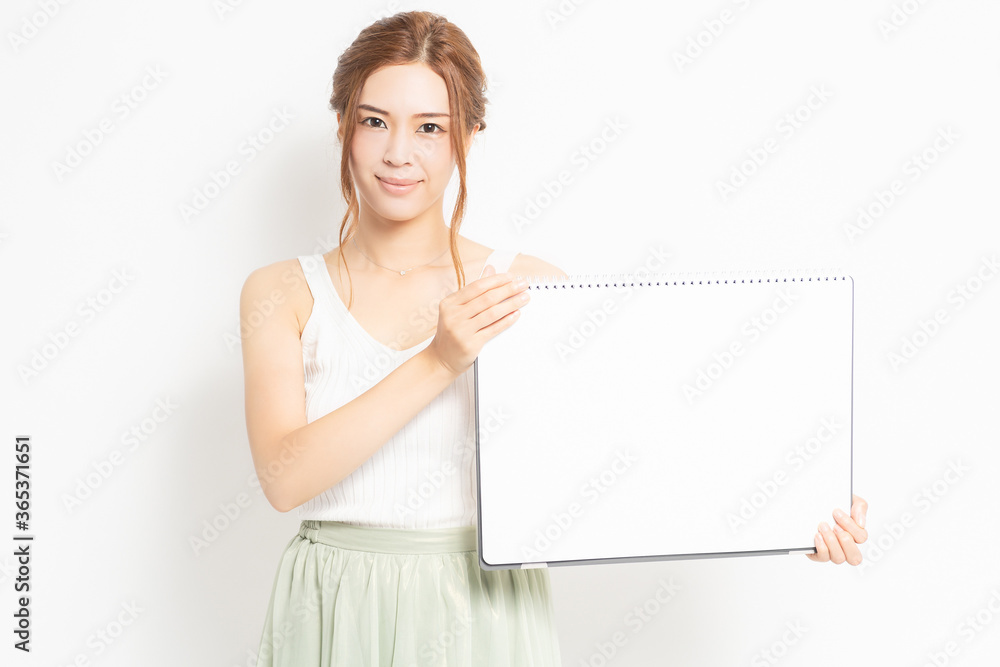 白紙のスケッチブックを持つ若い女性