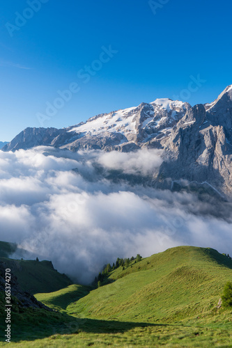 Clouds and fog at dawn from which the wonderful peaks of the Dolomites of Sesto spring up  Italy. Atmosphere of meditation and tranquility. High quality photo