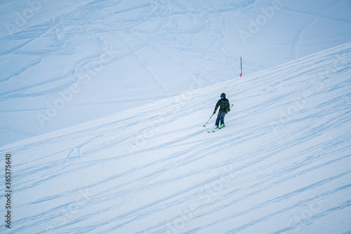 young woman skiing in the middle of the mountain. various trails in the snow of other skiers