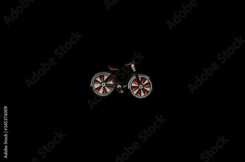 enameled metal brooch bicycle icon on a black background
