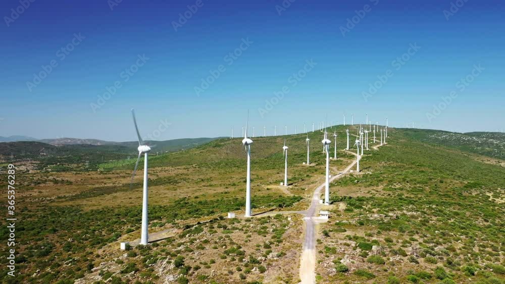 Wind Turbines Spinning. This stock video features turbines in a wind farm from an aerial perspective. Wind Turbines Spinning. This stock video features turbines in a wind farm from an aerial perspective.