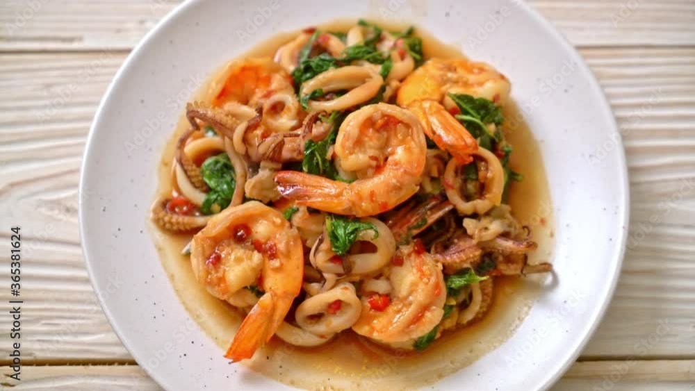 stir-fried seafood (shrimps and squid) with Thai basil - Asian food style stir-fried seafood (shrimps and squid) with Thai basil - Asian food style
