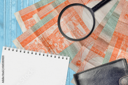 3 cuban pesos convertibles bills and magnifying glass with black purse and notepad. Concept of counterfeit money. Search for differences in details on money bills to detect fake photo