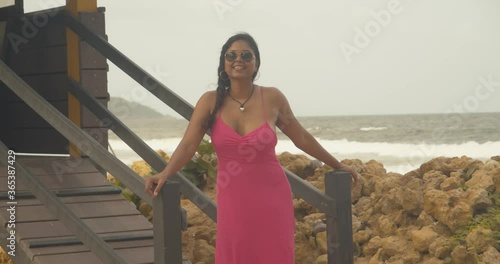 A sexy female acting as a lifeguard with waves crashing at the shoreline in the background photo