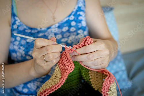Handiwork. Knitting. Handmade. A girl crochets a colored bag