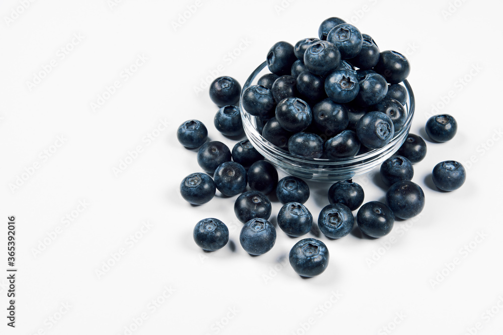 Freshly juicy picked blueberries in glass bowl isolated on white background. Top view. Selective focus. Free text space. Concept of healthy eating and nutrition.. Freshly juicy picked blueberries in glass bowl isolated on white background. Top view. Selective focus. Free text space. Concept of healthy eating and nutrition..