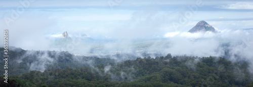 The peaks of Mt Beerwah and Mt Coonowrin, two of the Glasshouse Mountains, protrude above the heavy layer of fog surrounding the area, making for an awe inspiring and beautiful sight. panorama