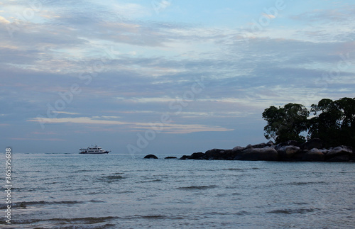 View of dawn at the seaside with the dramatic sky, boat and mountain, Tioman Island