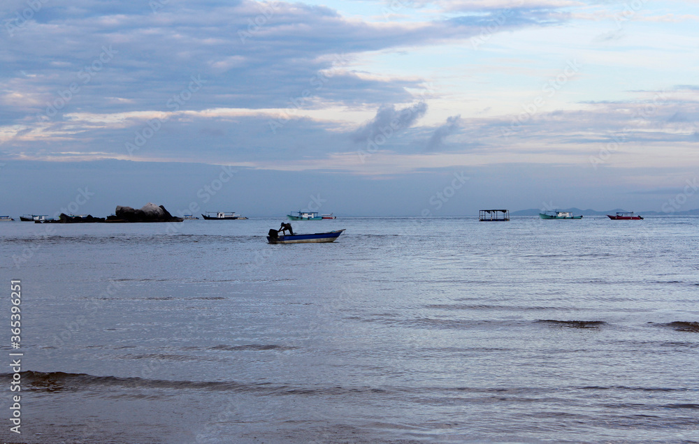 View of dawn at the seaside with a man start the engine on a boat, Tioman Island View of dawn at the seaside with a man start the engine on a boat, Tioman Island