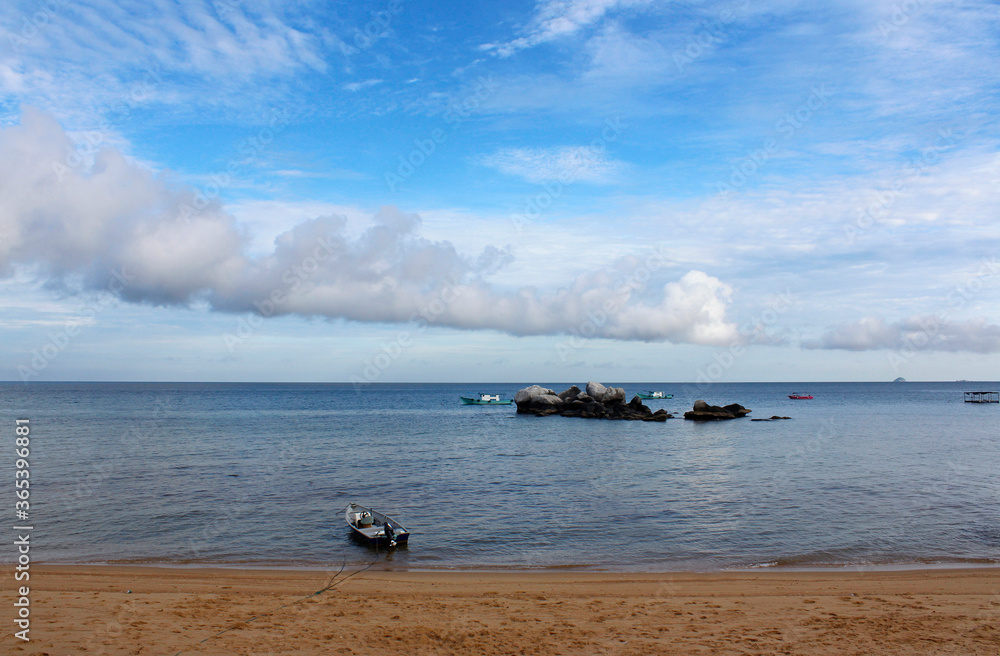 View of Tioman Island with the dramatic cloudscape, boats and rocks in the morning, Tioman Island
