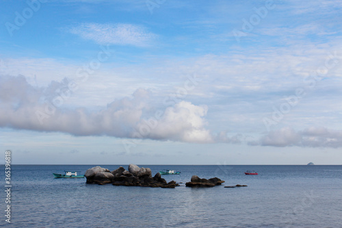 View of Tioman Island with the dramatic cloudscape, boats and rocks in the morning, Tioman Island