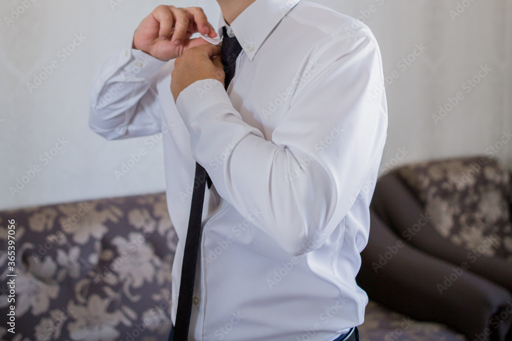 a man puts on a tie in front of a mirror a man puts on a tie in front of a mirror