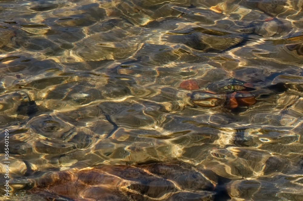 lake surface with small waves, stones below the surface