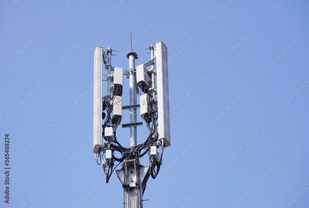 Telecommunication tower of 4G and 5G cellular. Macro Base Station. Wireless Communication Antenna Transmitter. Telecommunication tower with antennas against blue sky background.