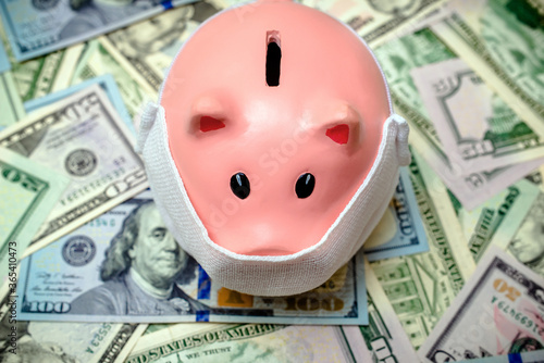 piggy bank in a mask on a background of american currency.The concept of coronavrius epidemic
