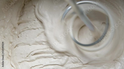 Slow motion pan shot of mixing concrete plaster with electric mixer. spatula and bucket with mortar on the construction site.