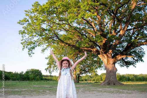 Huge Tree. a little girl by a big tree. child near with large green old oak