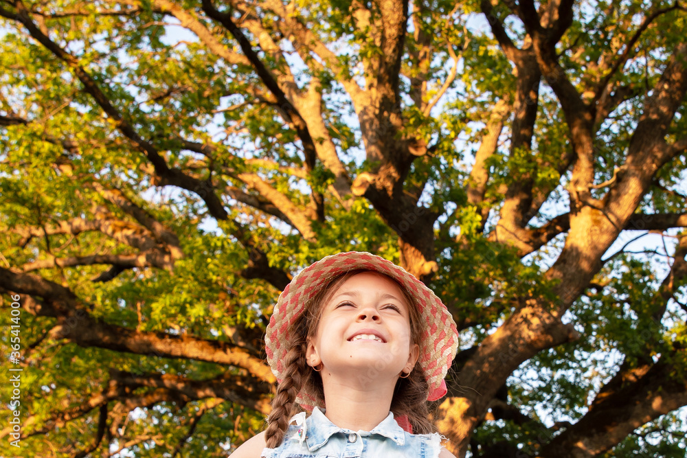 Huge Tree. a little girl by a big tree. child near with large green old oak Huge Tree. a little girl by a big tree. child near with large green old oak