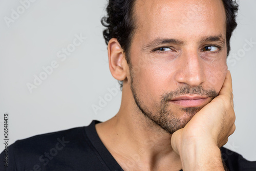 Portrait of handsome bearded Hispanic man with curly hair