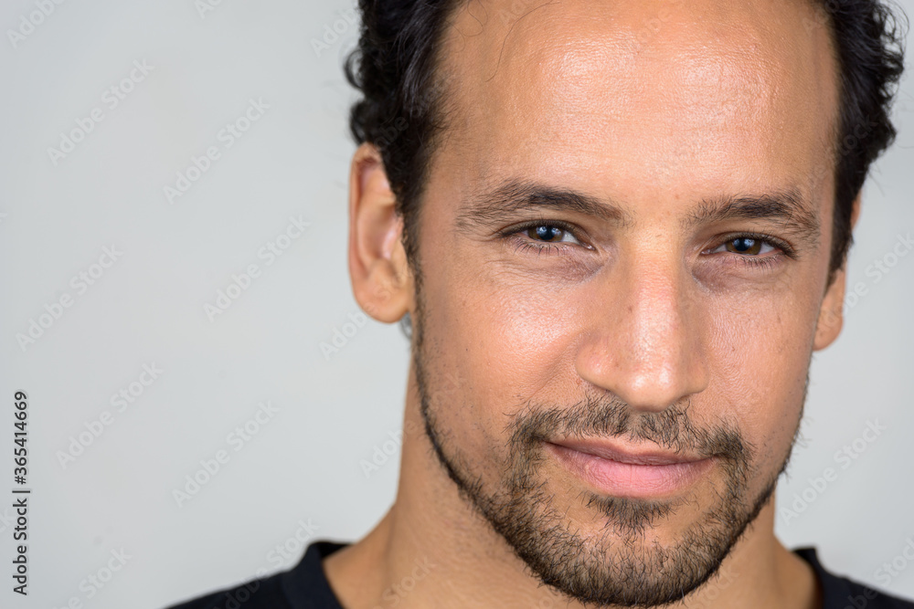 Fototapeta premium Portrait of handsome bearded Hispanic man with curly hair