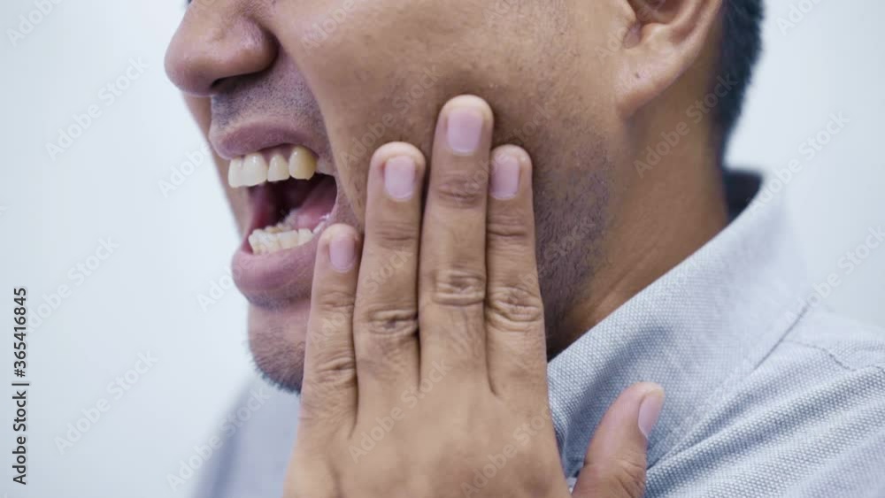 Office Syndrome. Asian man feeling pain in teeth while he eating snack, he get hurt and relieve toothache by his hand to holding on cheek. 4k Resolution. Office Syndrome. Asian man feeling pain in teeth while he eating snack, he get hurt and relieve toothache by his hand to holding on cheek. 4k Resolution.