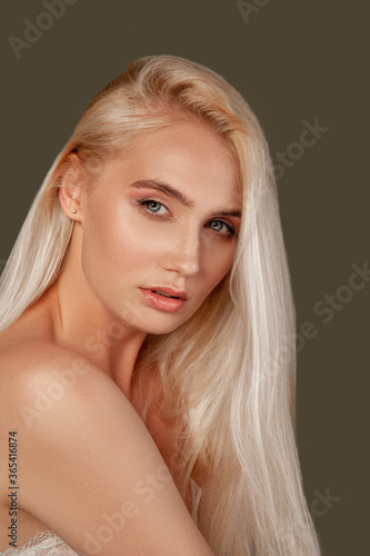 Pretty woman portrait. Skin rejuvenation. Blonde lady with natural makeup bare shoulder isolated on brown.