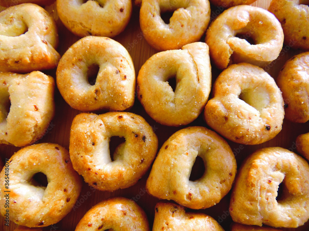 Taralli or tarallini - italian bagel pretzel regional apulia & puglia food. Taralli - traditional Italian food typical of Apulia regional cuisine, top view background. Salted bread sticks snack Taralli or tarallini - italian bagel pretzel regional apulia & puglia food. Taralli - traditional Italian food typical of Apulia regional cuisine, top view background. Salted bread sticks snack