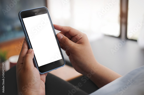 Cropped shot view of man hands holding smart phone with blank copy space screen for your text message or information content, female reading text message on cell telephone during in urban setting. 
