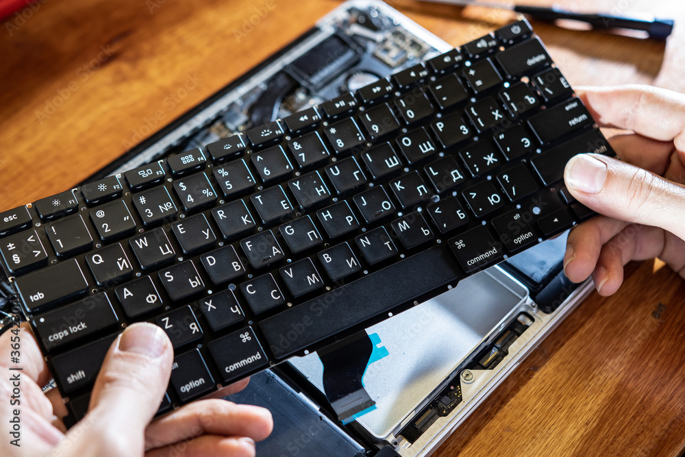 the master repairs the laptop: changes the battery, cleans the internal parts and the cooling system, changes the thermal grease and cleans the keyboard the master repairs the laptop: changes the battery, cleans the internal parts and the cooling system, changes the thermal grease and cleans the keyboard