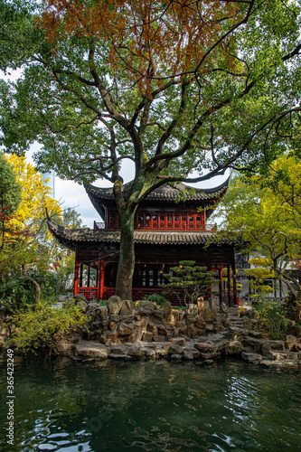 Traditional Chinese architecture in Yu Garden of Shanghai. Ancient pagoda building in garden of autumn trees on pond shore