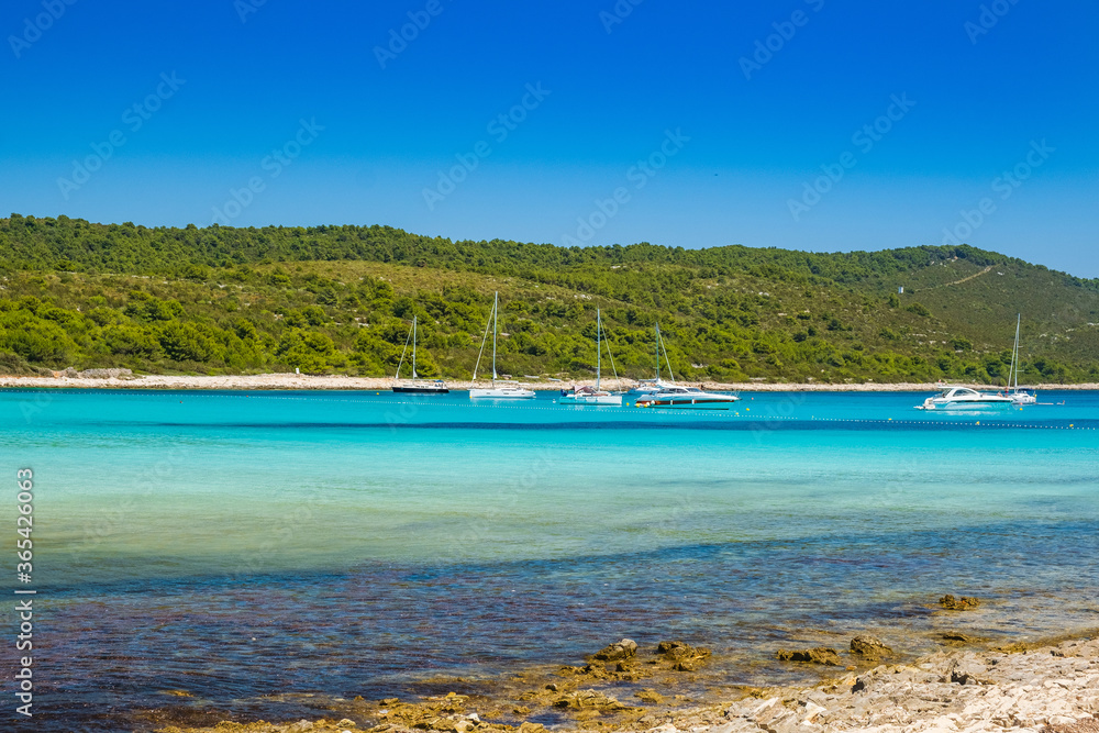 Azure turquoise lagoon on Sakarun beach on Dugi Otok island, Croatia, yachts anchored in clear sea water.