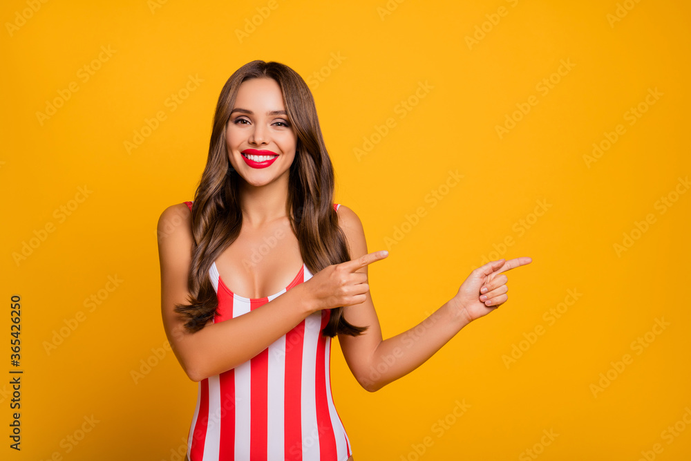 Photo of attractive lady arms fingers directing side empty space showing tourism low cost tickets traveling banner wear striped red white bodysuit isolated yellow color background Photo of attractive lady arms fingers directing side empty space showing tourism low cost tickets traveling banner wear striped red white bodysuit isolated yellow color background