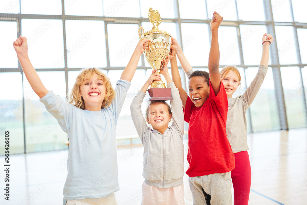 Fototapeta premium Successful children team with cup cheers