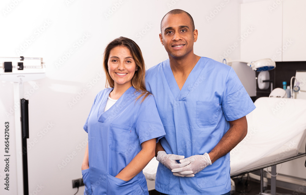 Obraz premium Portrait of qualified female and male cosmetologists smiling confidently in medical center