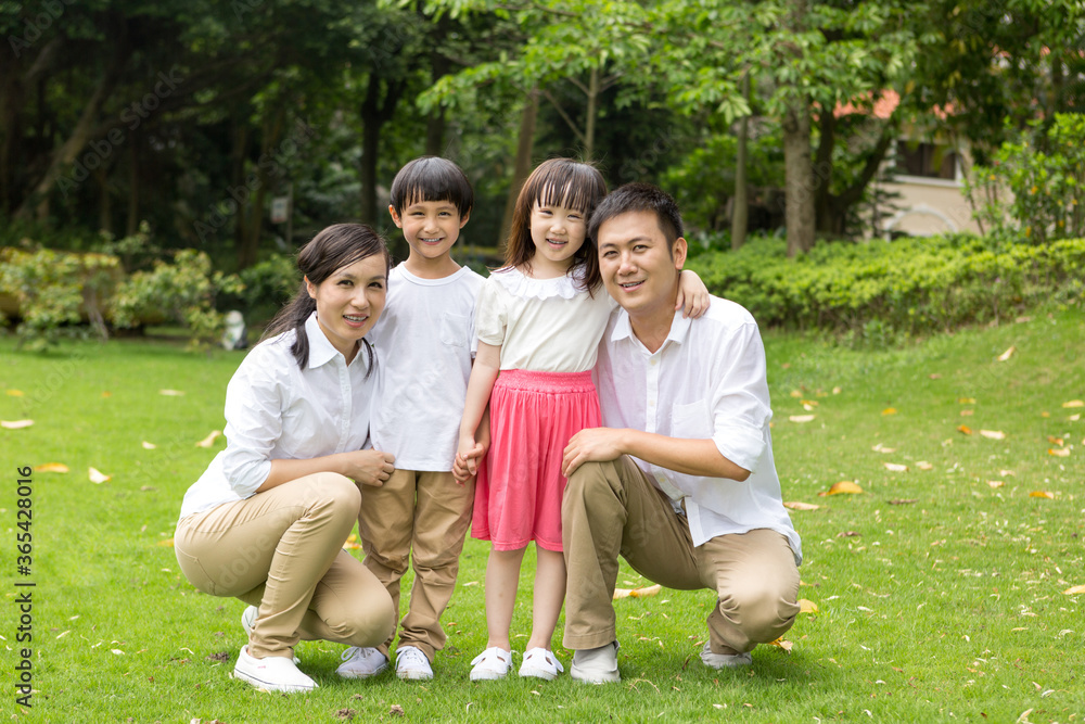 Happy family smiling together on the grass Happy family smiling together on the grass