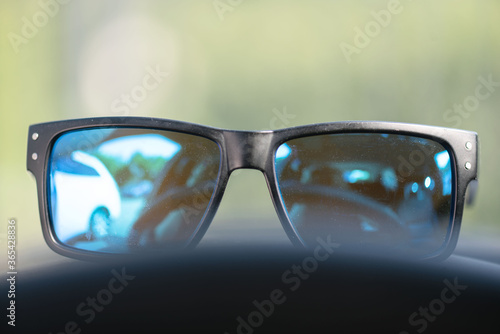 Sunglasses on car dashboard background.