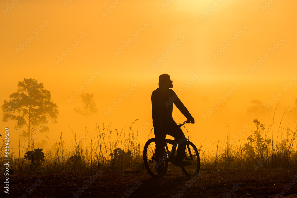 Silhouette of people Cyclist look at view in the morning Silhouette of people Cyclist look at view in the morning