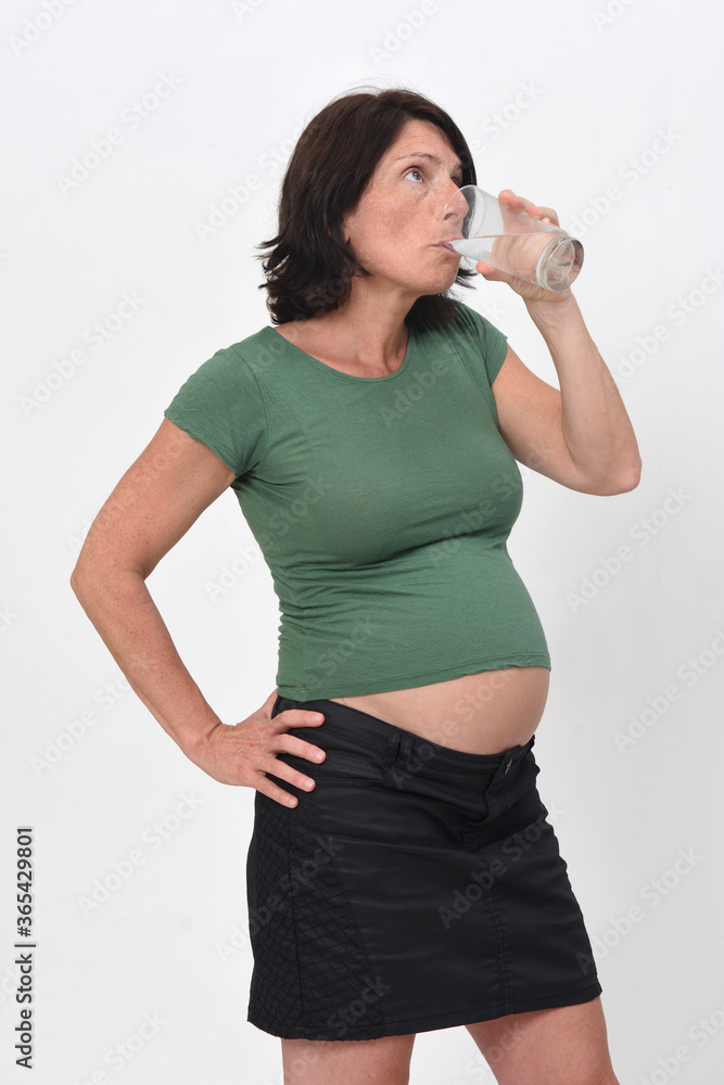 pregnant woman drinking a glass of water on white background. pregnant woman drinking a glass of water on white background.