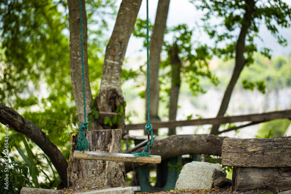 Wooden swing in the garden for relaxation with blur background Wooden swing in the garden for relaxation with blur background
