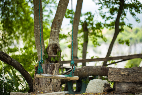 Wooden swing in the garden for relaxation with blur background