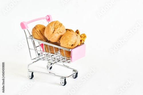 Shopping cart with walnuts isolated on a white background. healthy food concept. place for text.