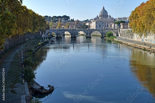 view of the tiber river in autumn with the vatican in the background photo