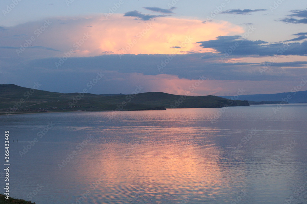 Baikal Lake in summer. Sunset. View of the natural landmark of Olkhon Island - Shamanka Rock. Lake natural background. Beautiful landscape background with copy space