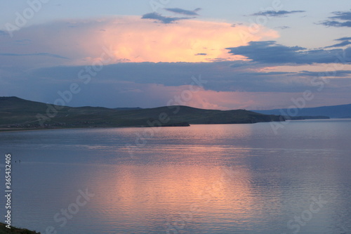 Baikal Lake in summer. Sunset. View of the natural landmark of Olkhon Island - Shamanka Rock. Lake natural background. Beautiful landscape background with copy space