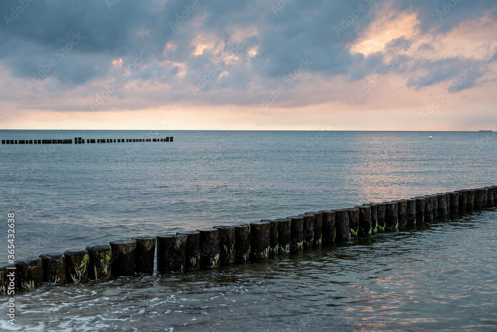 Sunset at the beach, groynes in Kuehlungsborn, Germany