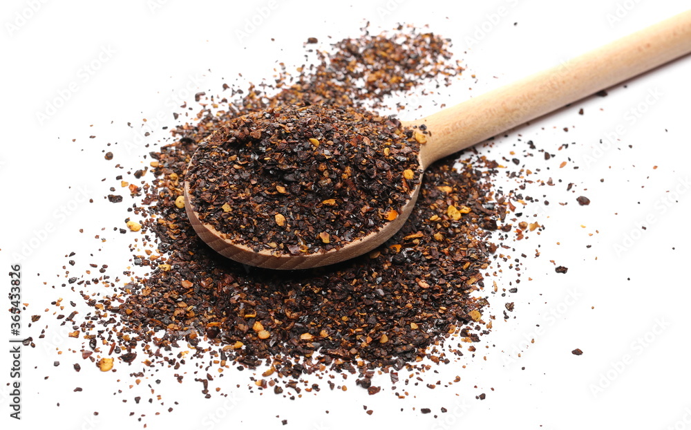 Aromatic spicy chili pepper flakes, dry ancho chili pile with wooden spoon isolated on white background Aromatic spicy chili pepper flakes, dry ancho chili pile with wooden spoon isolated on white background